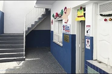 Escada de acesso aos pavimentos superiores do colégio, com sinalização nas paredes