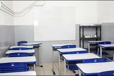 Sala de aula do Colégio Terceira Dimensão, com carteiras individuais azuis e quadro branco